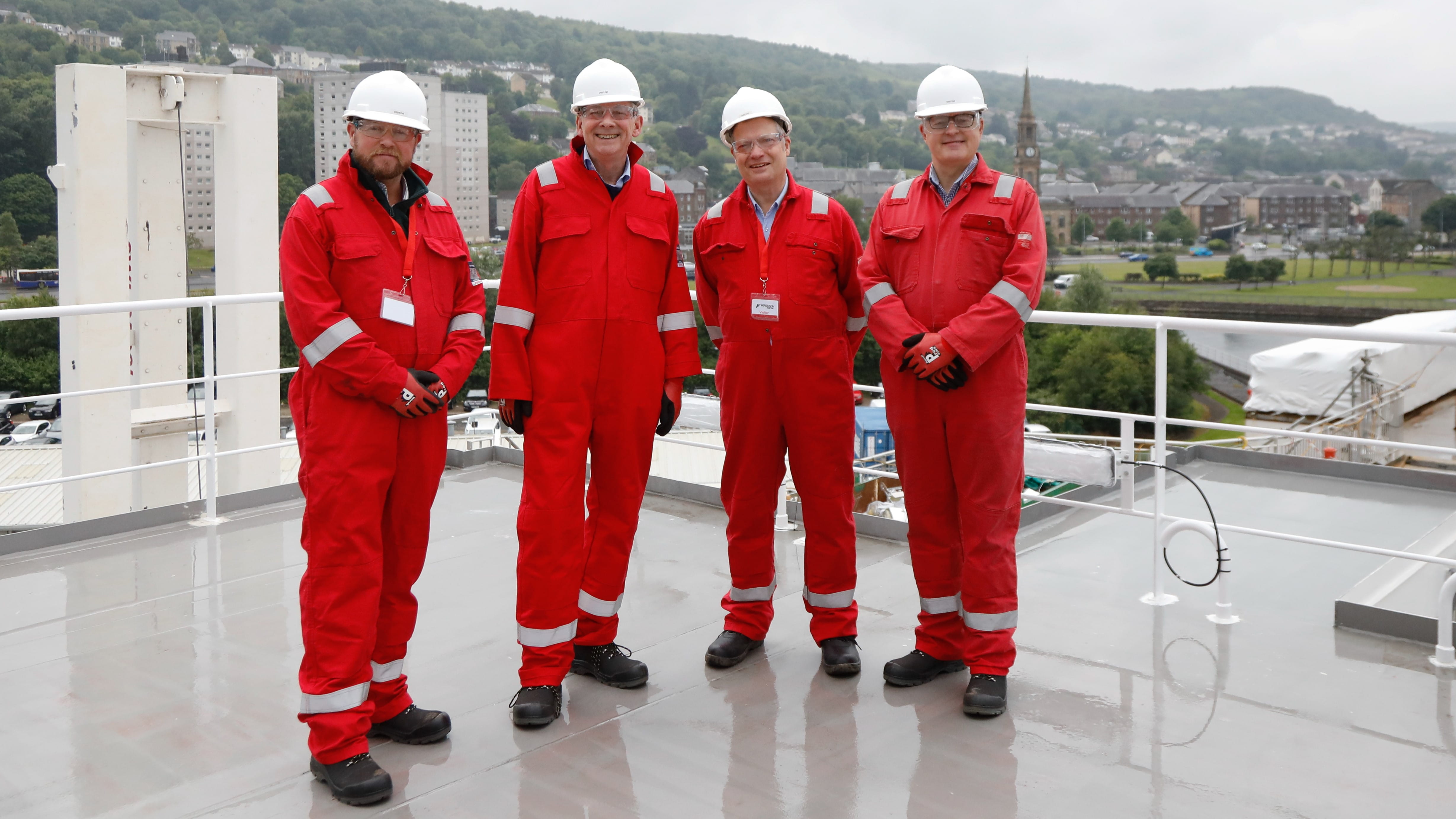 A photograph of four members of the Public Audit Committee standing on the deck of the MV Glen Rosa in Port Glasgow on 9 June 2025